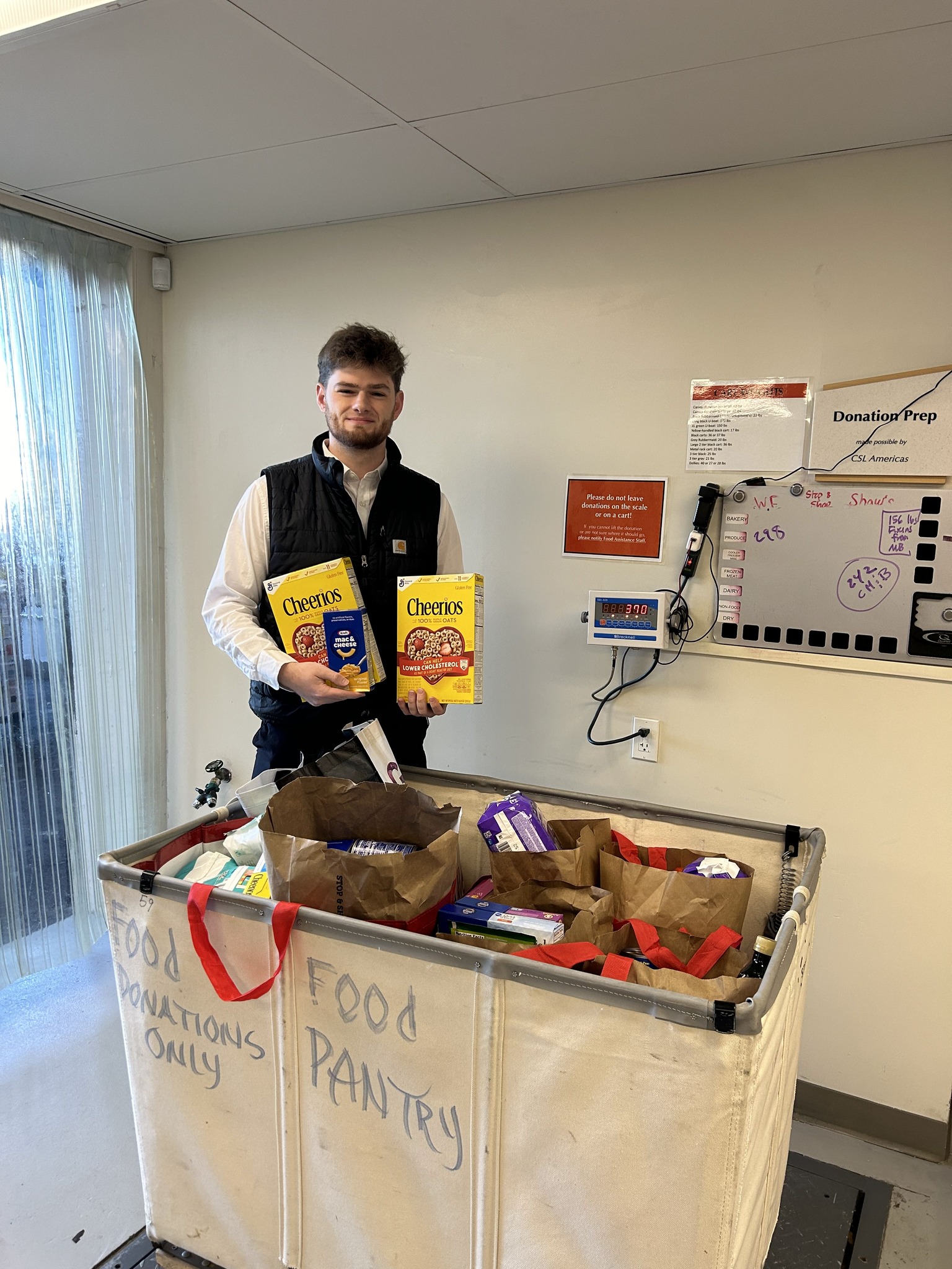 posing in front of food donations bin