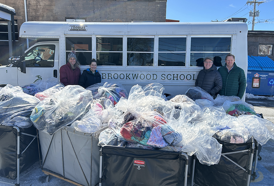 Brookwood School in front of their bus with hundreds of bags of donated thrift merchandise