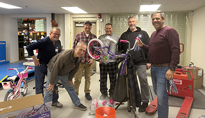 A group of volunteers assembles bikes for children